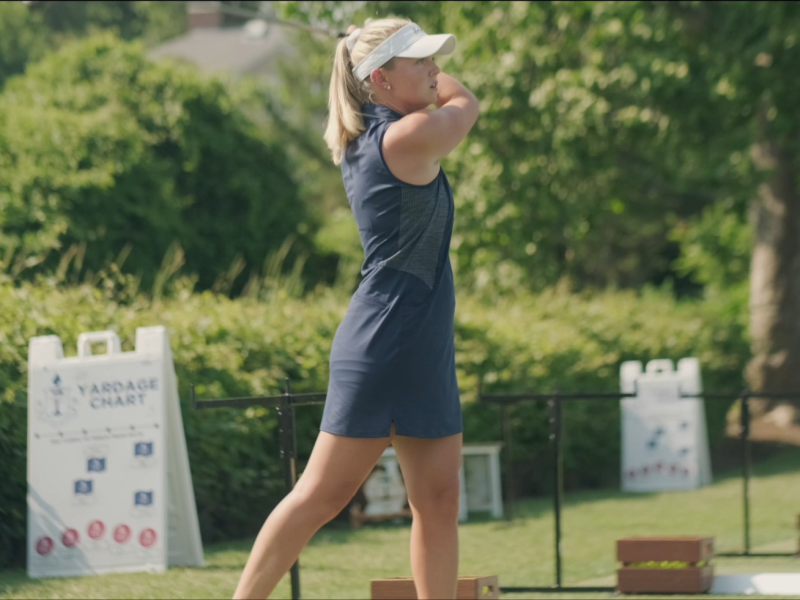 Abby Barton watches her golf ball in the air after taking a swing.