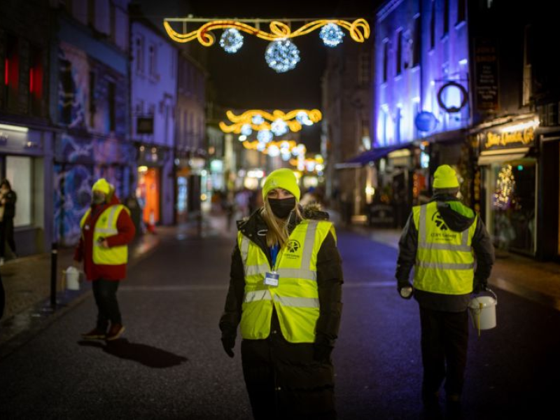 Wayfair employee Tamara McGough stands in a reflective yellow vest outside at night for COPE Galway's event.
