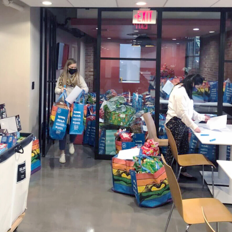 Two women unloading bags of food and donations.