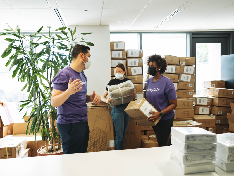 Wayfair employees assembling bedding kits for John and Jill Ker Conway residents. 