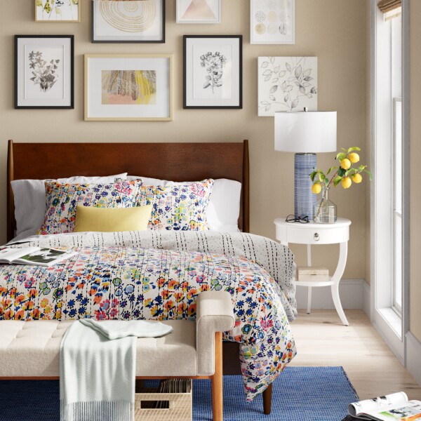 CGI Image of bedroom with gallery wall frames behind headboard and a colorful floral comforter on the bed