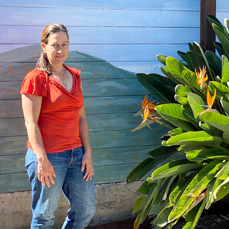 Woman standing in front of nature mural.