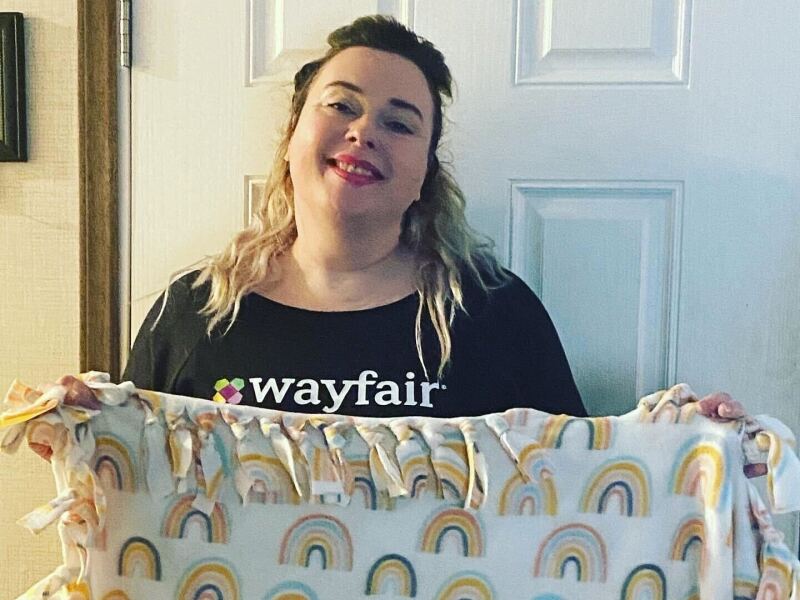 Pictured: Christa Boody showcases a blanket she's made.