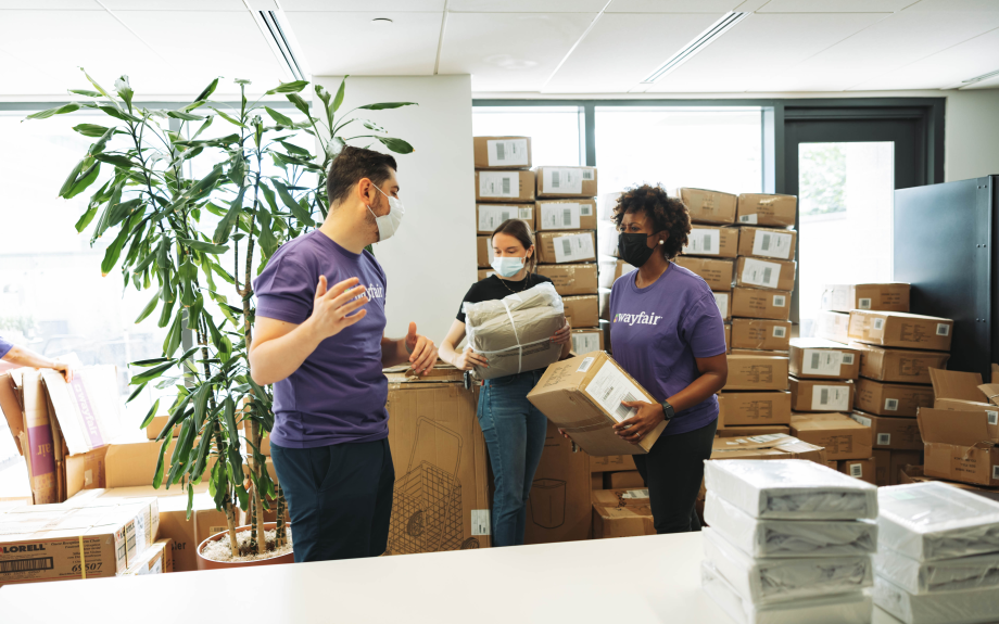 Wayfair employees assembling bedding kits for John and Jill Ker Conway residents.