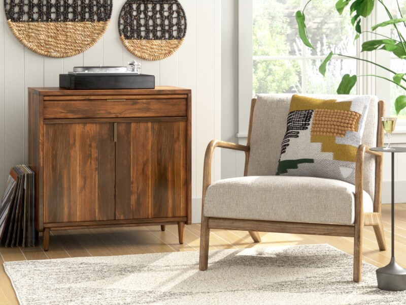 3 d modeling imagery of armchair in living room with a plant to right and a console to left